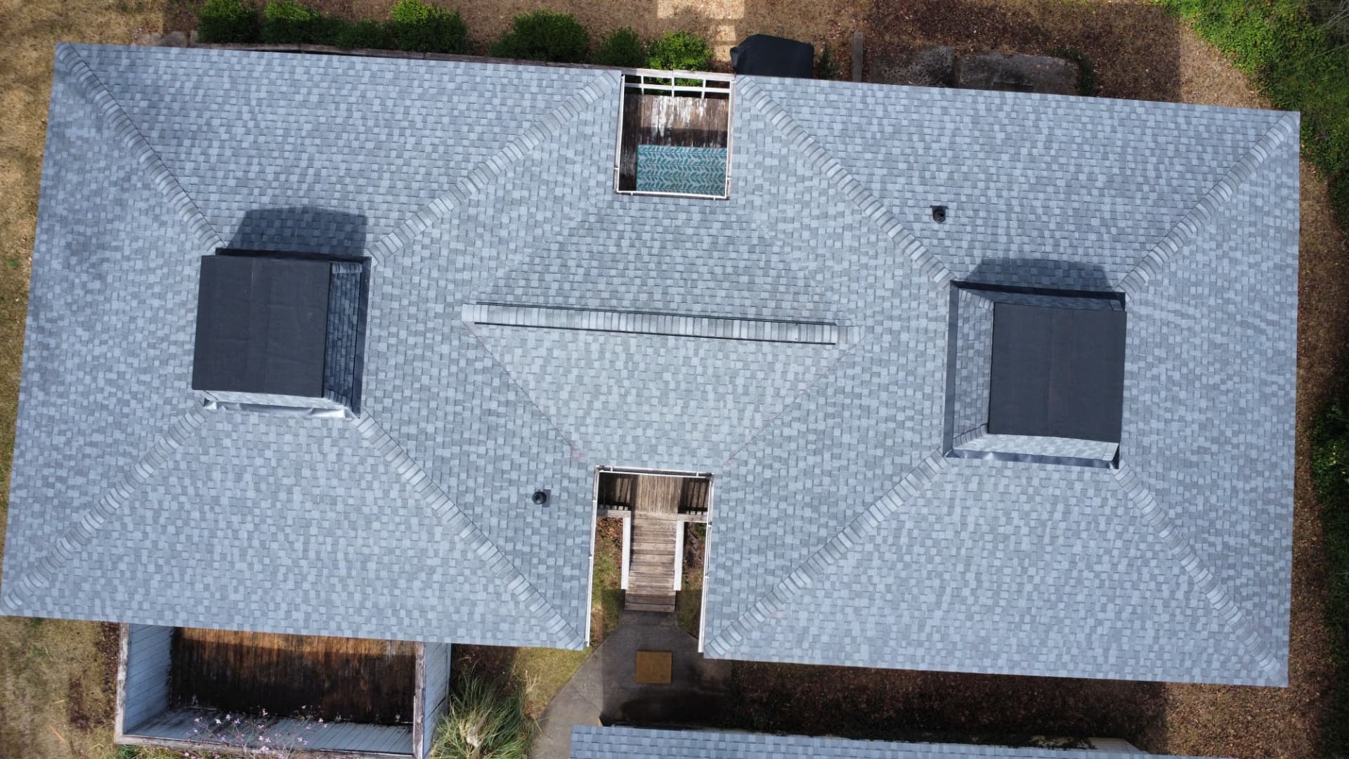 Overhead drone view of a completed gray shingle roof replacement by Coster Roofing Co in Upstate South Carolina