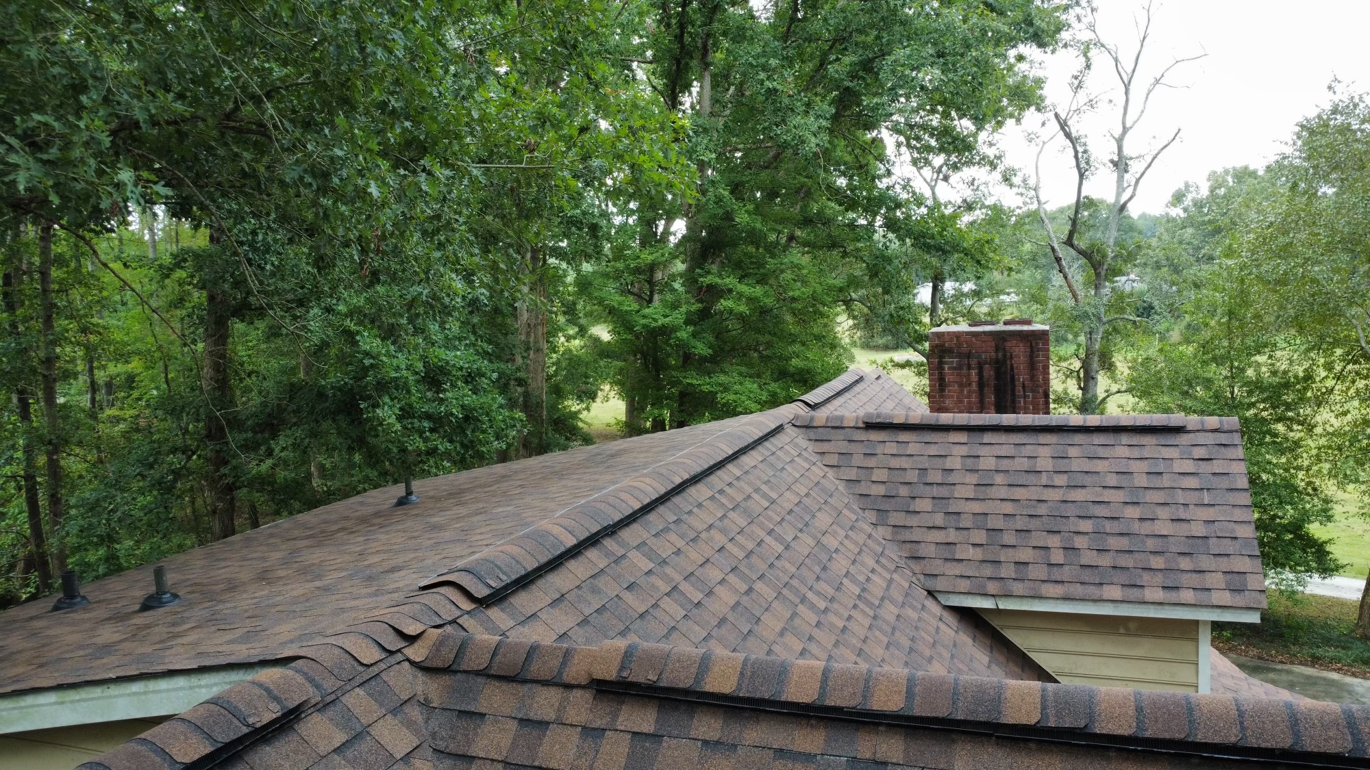 Drone view of a completed brown blend CertainTeed architectural shingle roof with brick chimney near Ninety Six SC