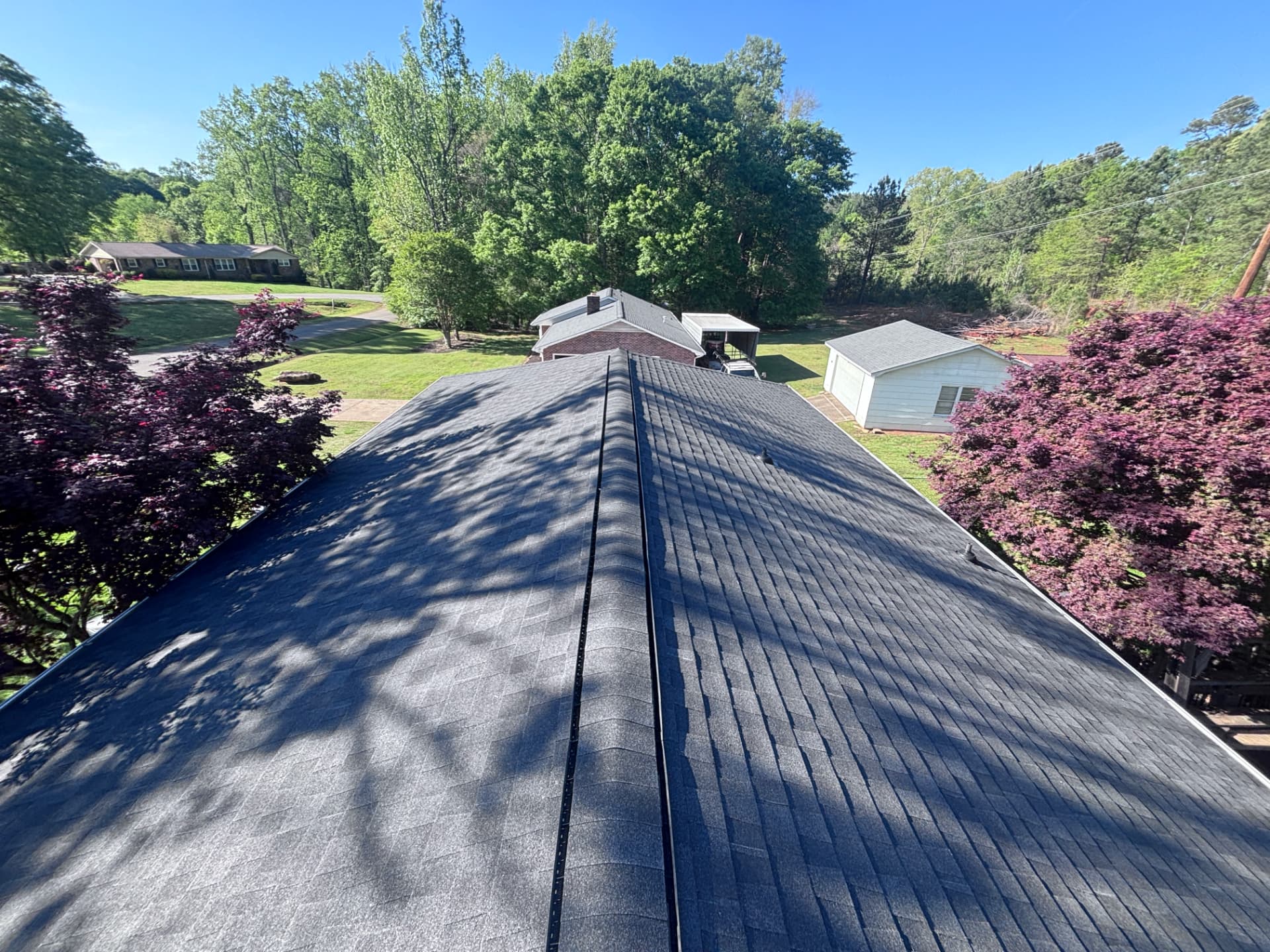 Long ridge line of a new charcoal architectural shingle roof installed by Coster Roofing Co in Abbeville SC