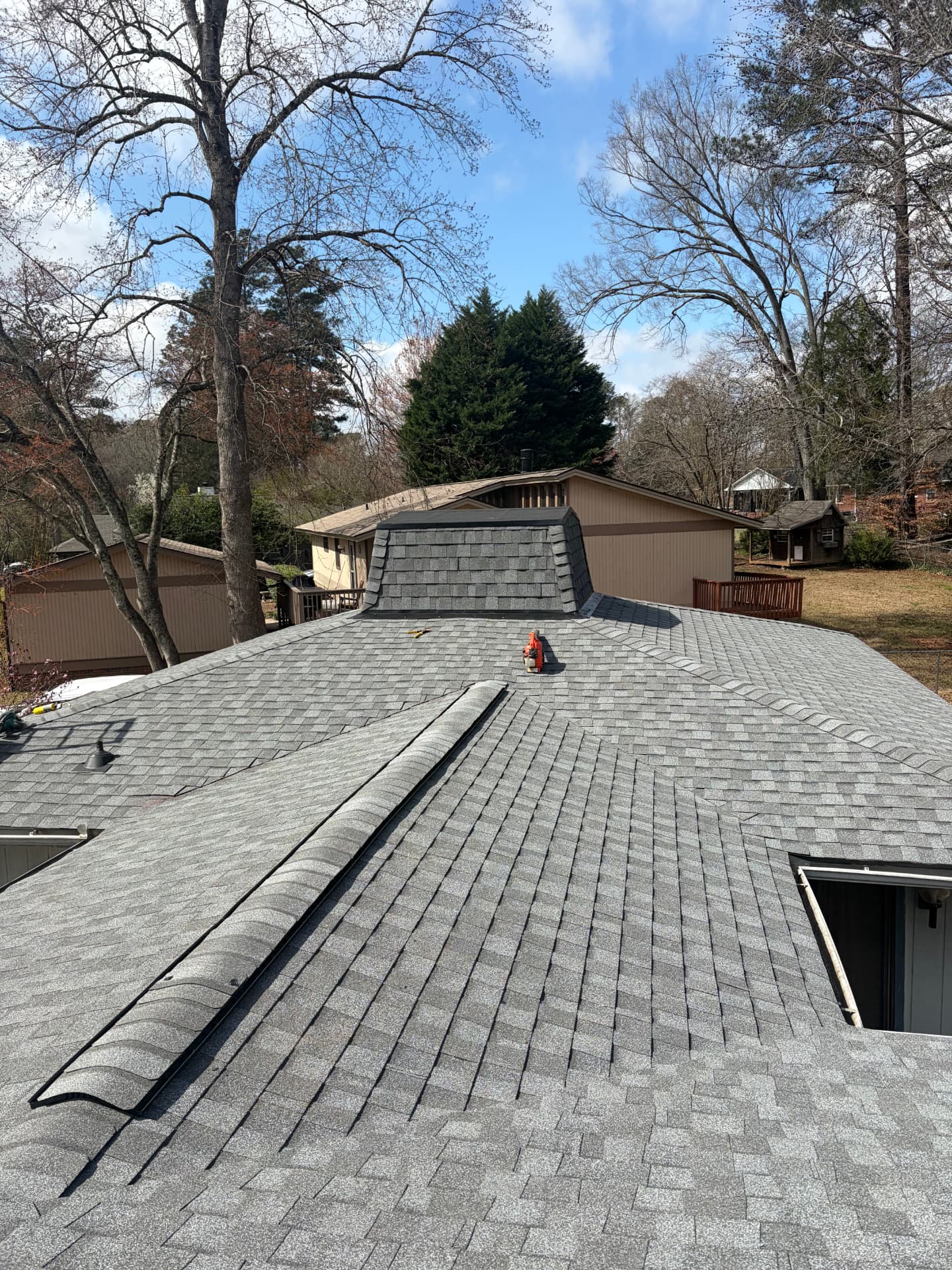 New gray architectural shingle roof with dormer and ridge vent detail installed by Coster Roofing Co in Saluda SC